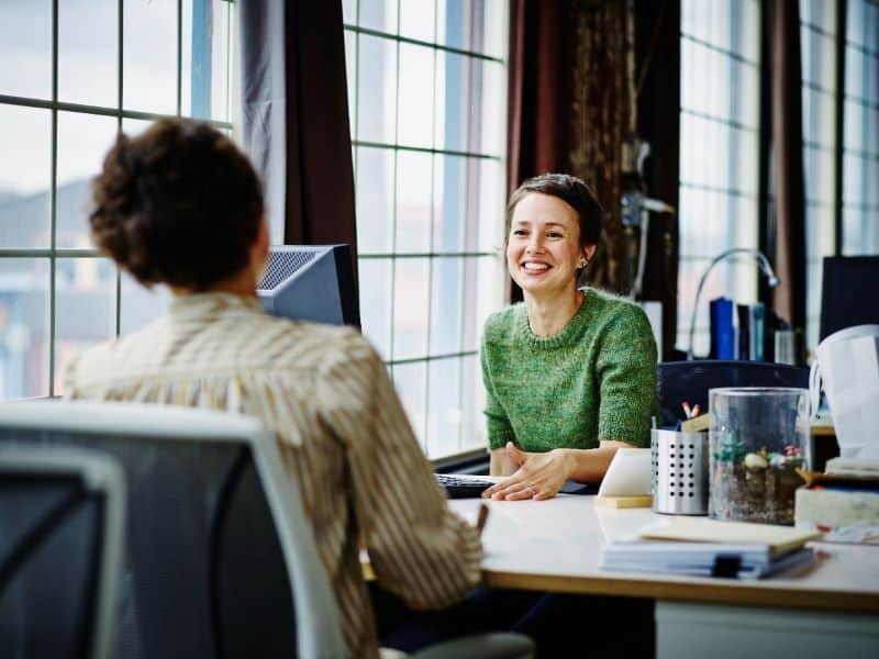 Women Sitting at Desk talking about humanizing their brand